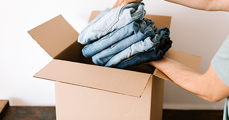 Apparel Software Management - Man putting jeans inside box for shipping